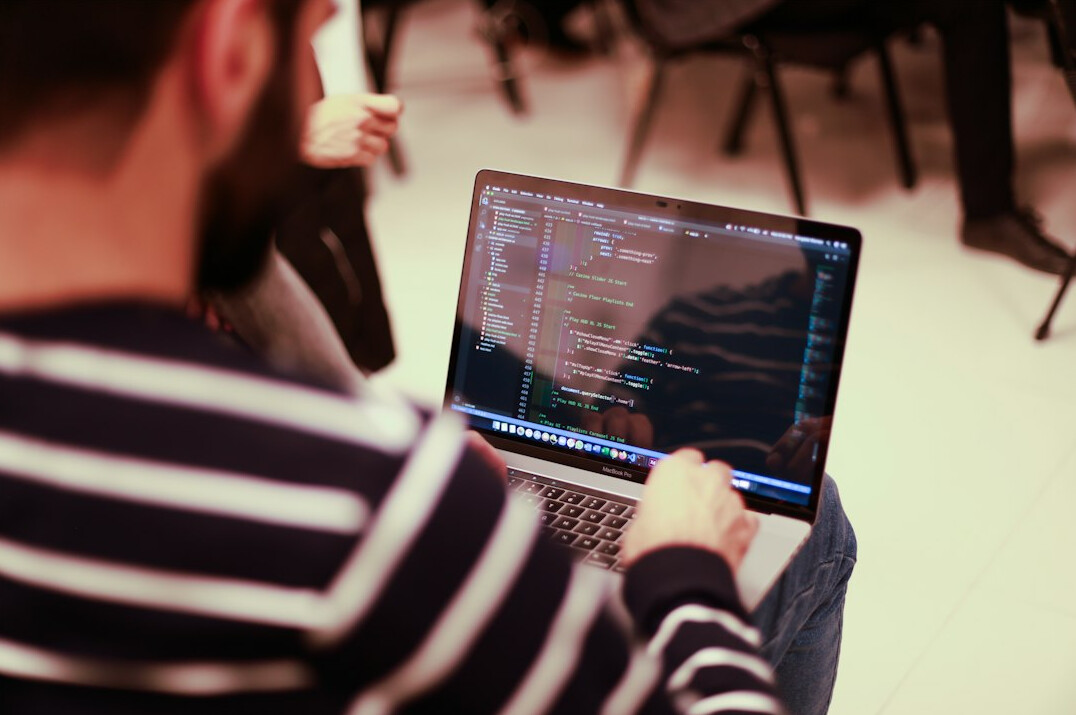 young programmer coding on laptop